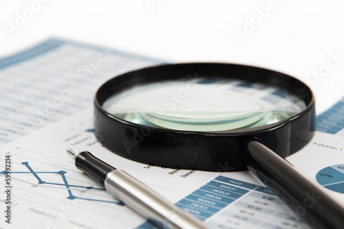 magnifying glass and pen over graph