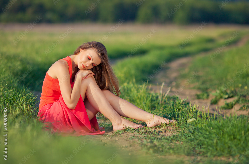 Portrait of a woman in red on a background of sky and grass Portrait of a woman in red on a background of sky and grass