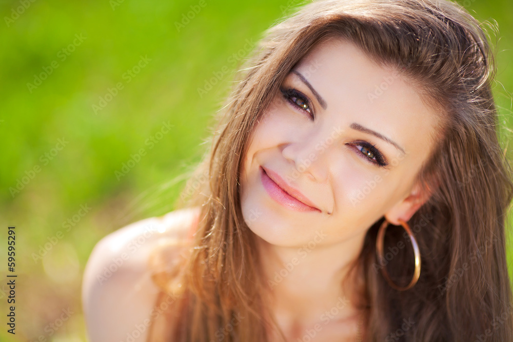 Portrait of a woman in red on a background of sky and grass