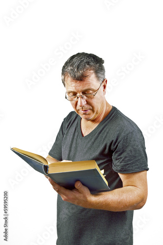 man with glasses reading in a book photo