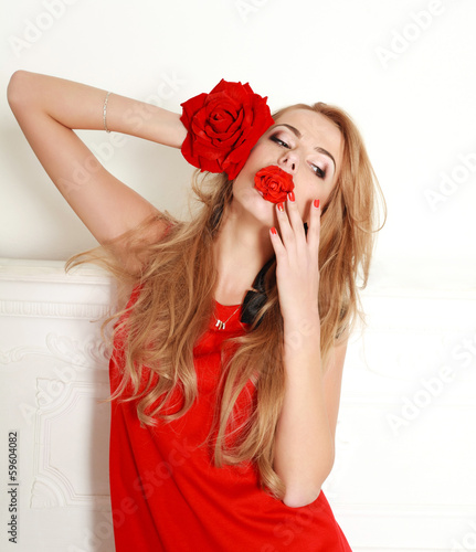 Blond woman with red rose in studio, girl and flower