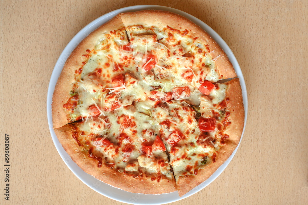 Pizza with tomatoes, cheese and herbs on a plate Pizza with tomatoes, cheese and herbs on a plate