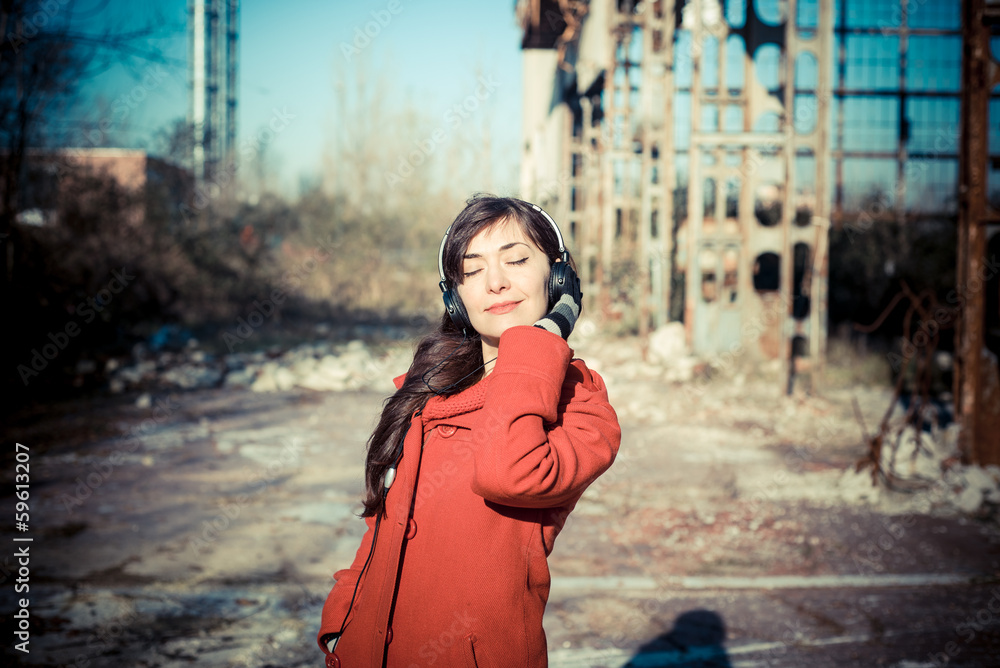 Fototapeta premium beautiful woman red coat listening music park