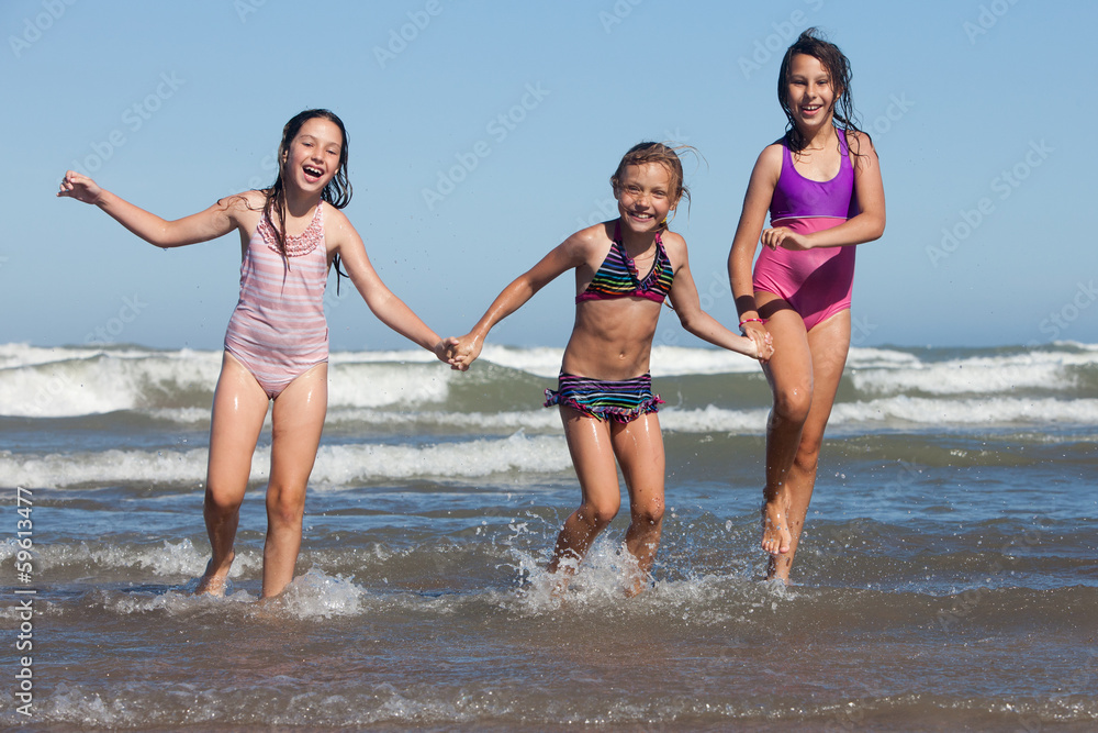 three happy girls running out of ocean three happy girls running out of ocean