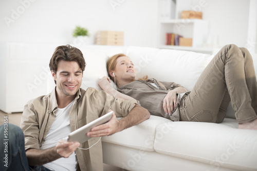 young couple sharing music on tablet