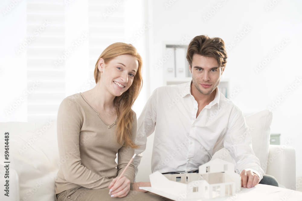 Fototapeta premium Couple studying a construction project with a model house