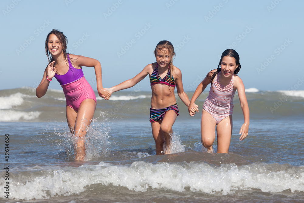 three happy girls running out of ocean three happy girls running out of ocean