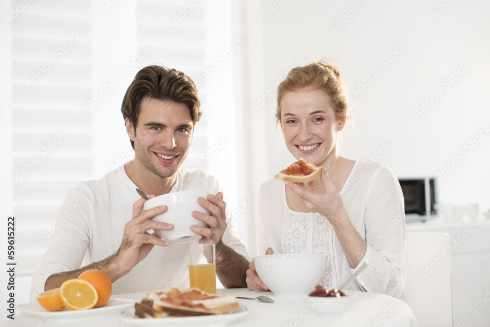 young couple takes breakfast in kitchen young couple takes breakfast in kitchen