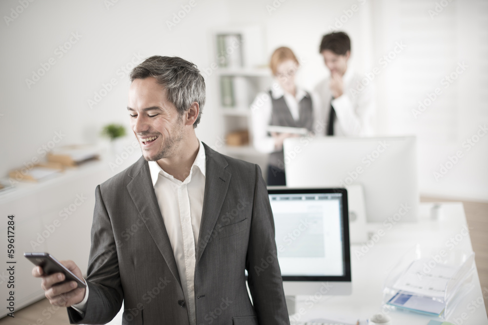 portrait of a businessman watching his smartphone at office portrait of a businessman watching his smartphone at office