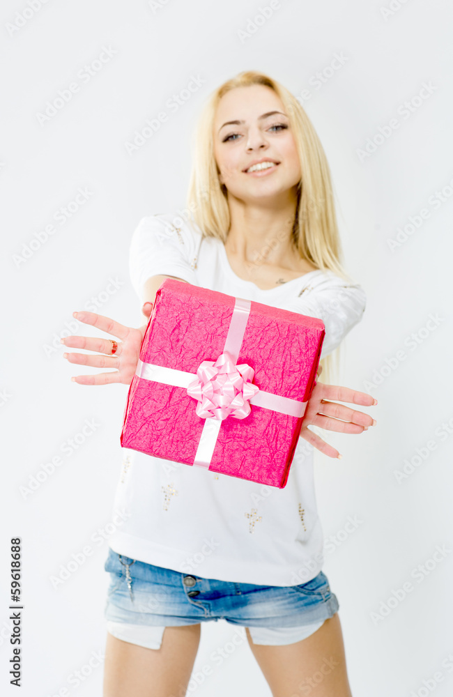 Young, cheerful girl holding a gift, isolated on white backgroun Young, cheerful girl holding a gift, isolated on white backgroun