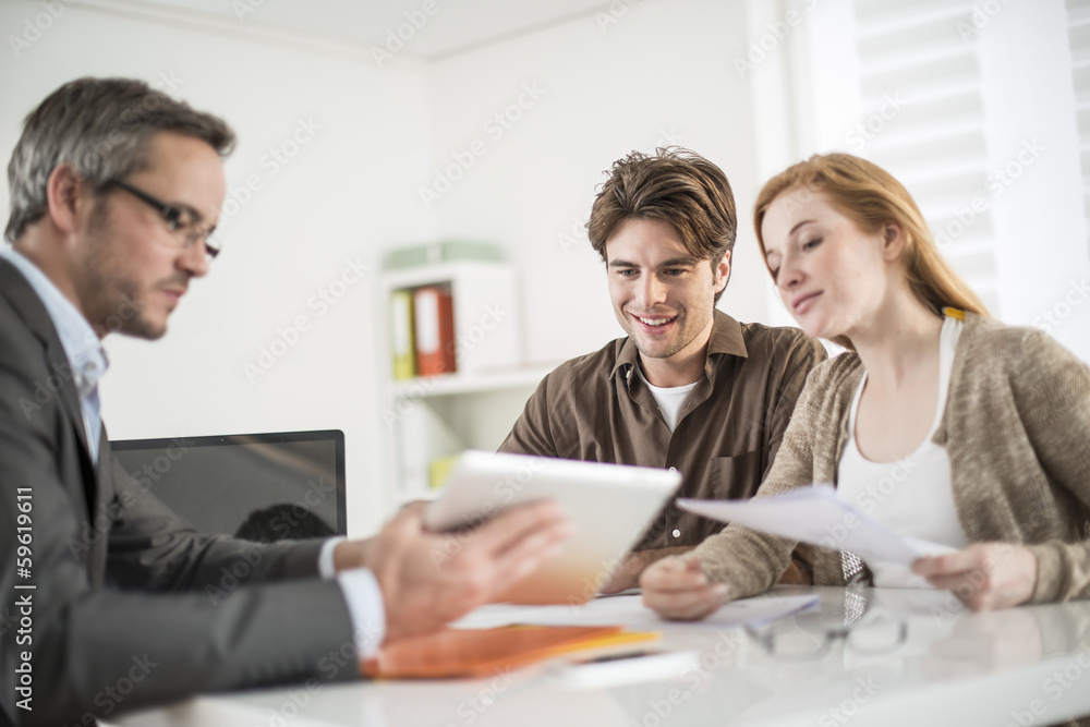 real-estate agent shows a build project on a digital tablet to a real-estate agent shows a build project on a digital tablet to a
