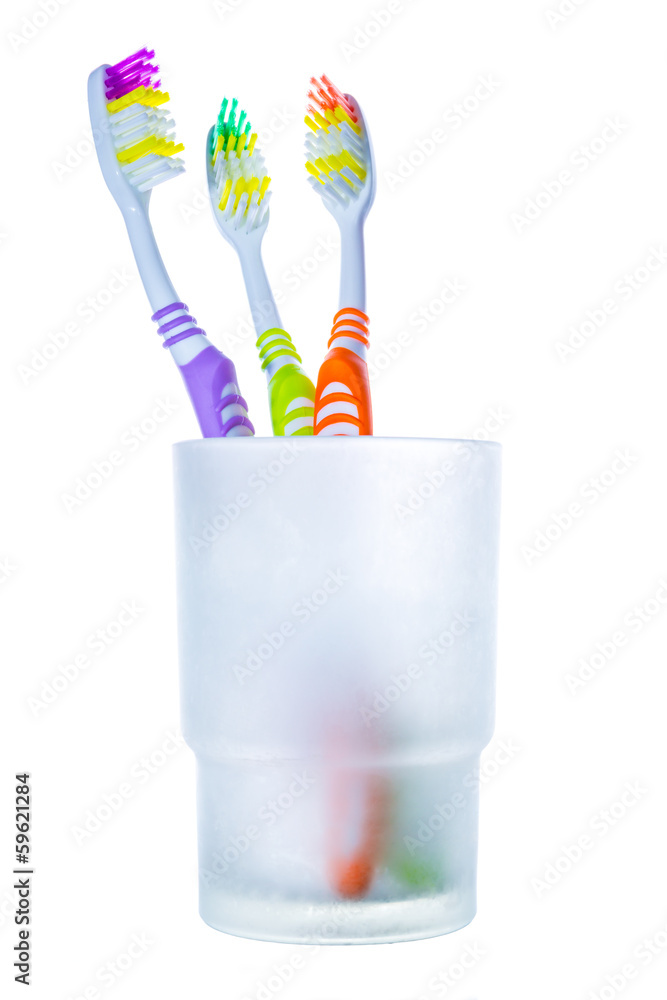 Three colorful toothbrushes in glass Three colorful toothbrushes in glass