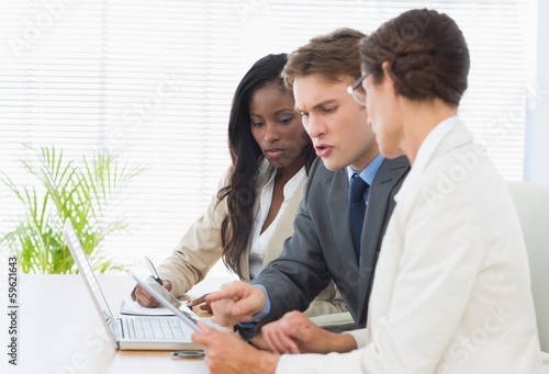 Colleagues with laptop and digital tablet in meeting at desk