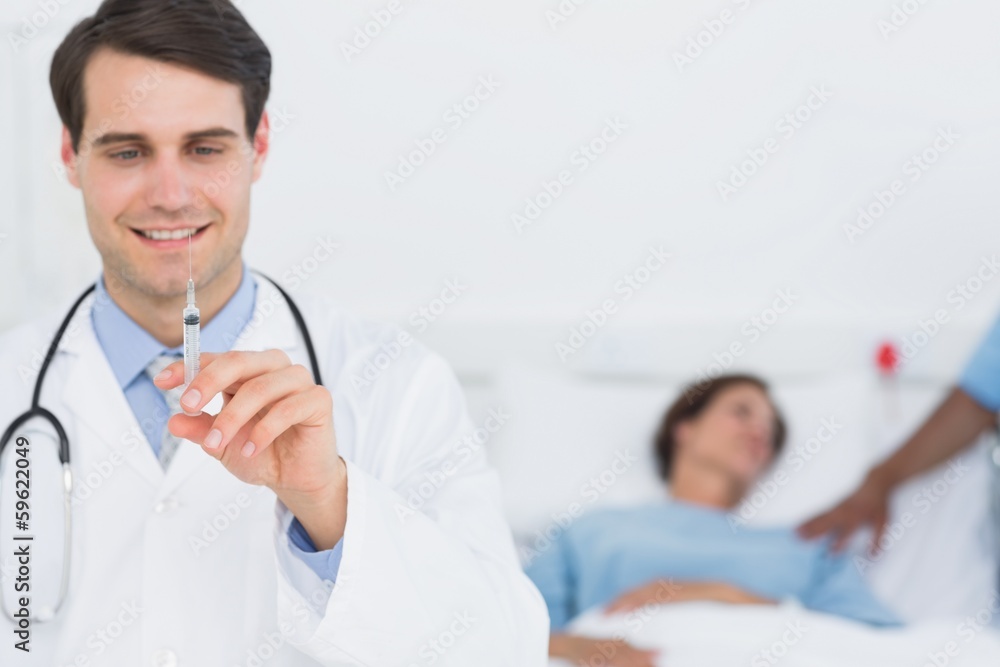 Male doctor holding an injection in the hospital Male doctor holding an injection in the hospital