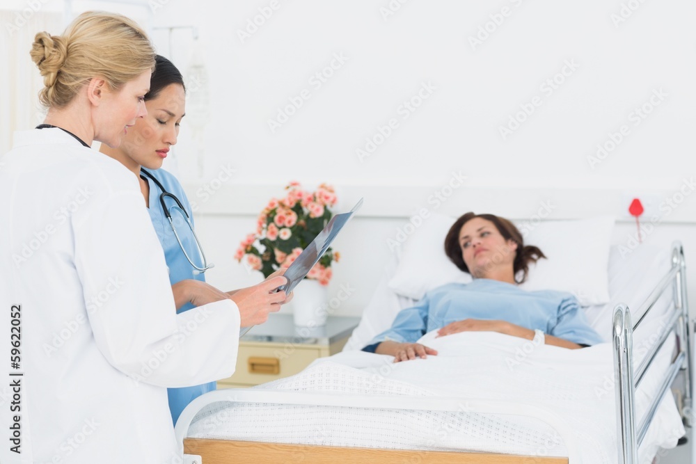Fototapeta premium Doctor and surgeon visiting female patient