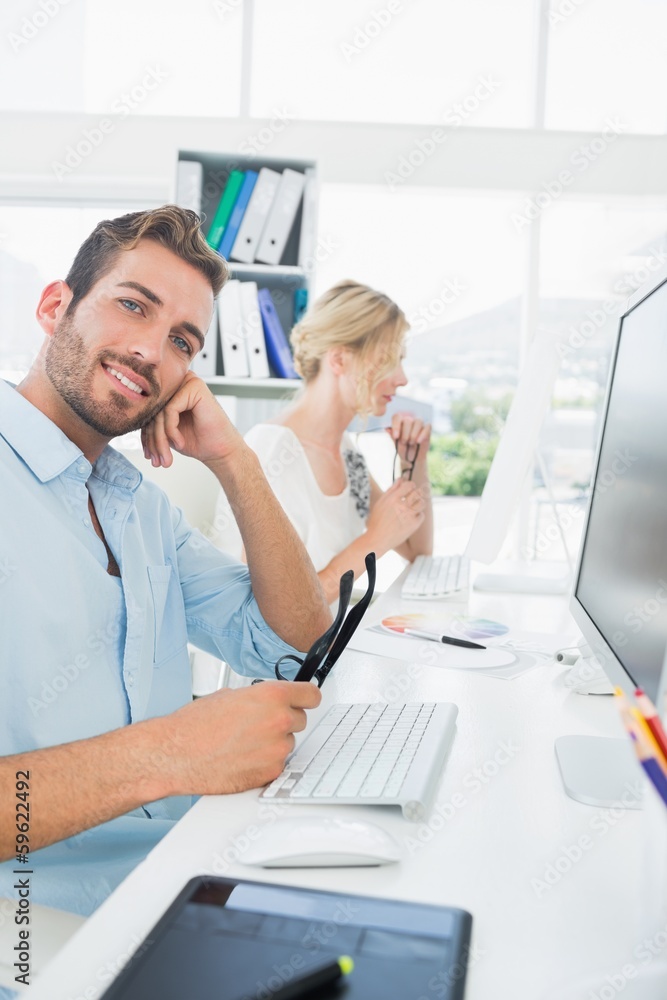 Obraz premium Smiling casual young couple working on computer