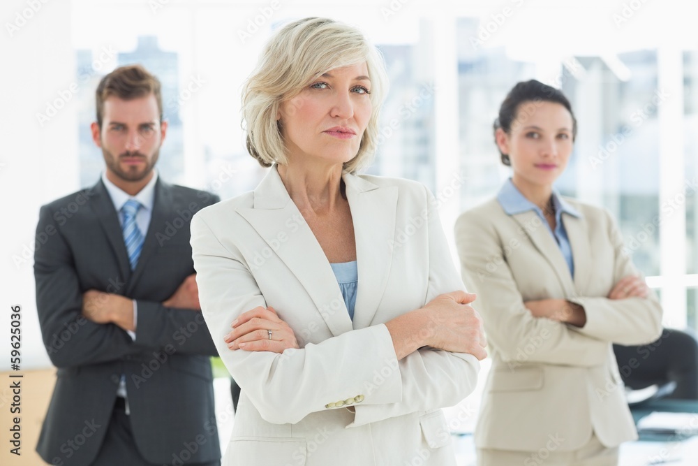 Confident business team with arms crossed in office Confident business team with arms crossed in office