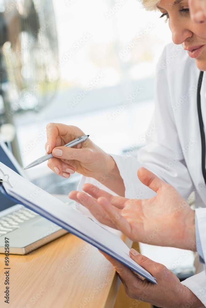 Close-up mid section of two doctors in meeting Close-up mid section of two doctors in meeting