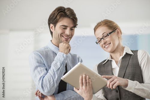 two colleagues discuss around a digital tablet © jackfrog