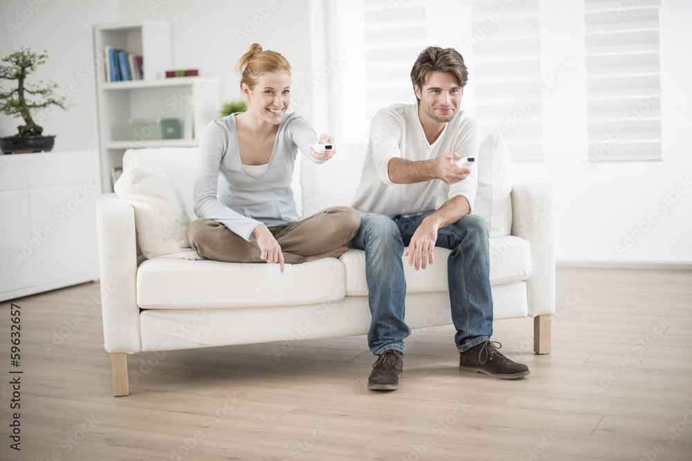 cheerful couple play to video game on a couch