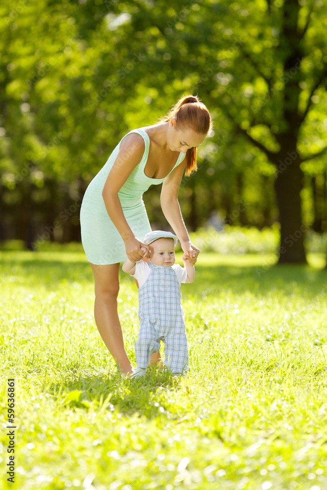 Cute little baby in the park with mother on the grass. Sweet bab Cute little baby in the park with mother on the grass. Sweet bab