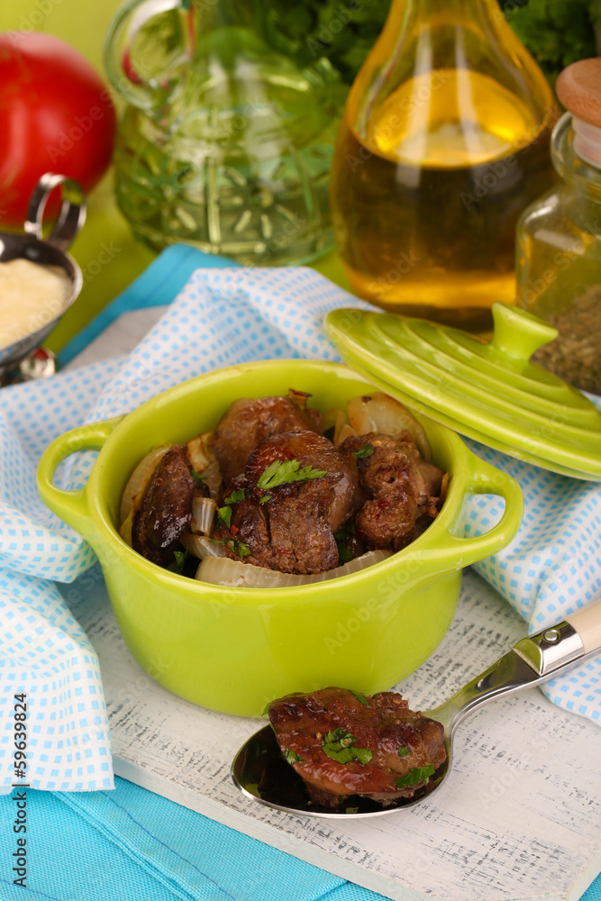 Fried chicken livers in pan on wooden table close-up Fried chicken livers in pan on wooden table close-up