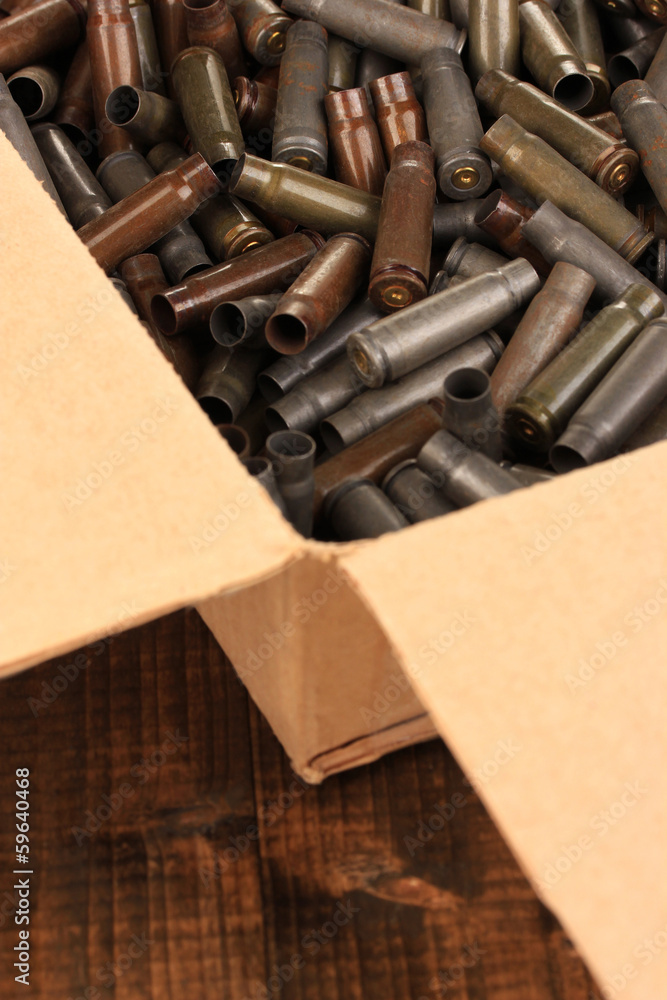 Shotgun cartridges in box on wooden table close-up Shotgun cartridges in box on wooden table close-up