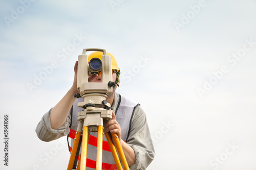 Surveyor engineer making measure with cloud background photo