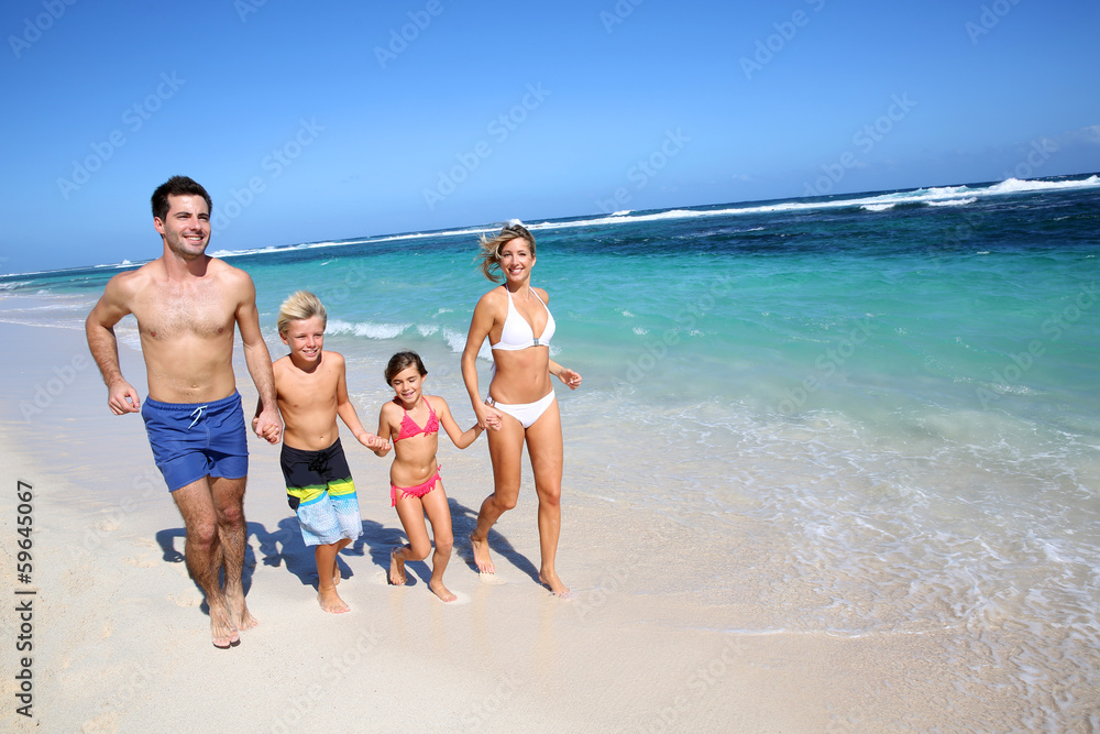 Family running on a sandy beach