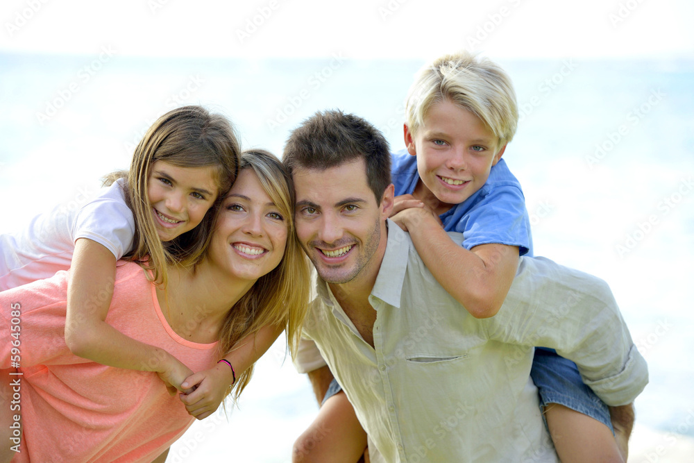 Cheerful parents holding kids on their back Cheerful parents holding kids on their back