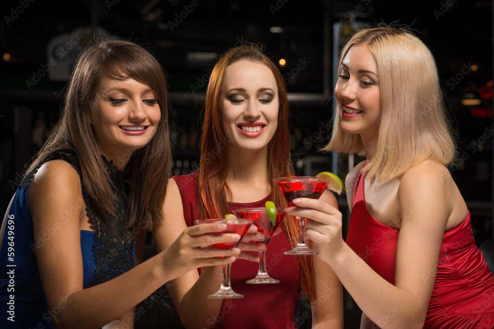 three girls raised their glasses in a nightclub three girls raised their glasses in a nightclub