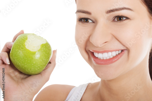 Beautiful young woman eating apple.