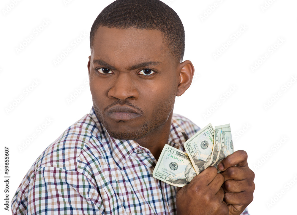 Closeup portrait of greedy man holding dollar banknotes tightly Closeup portrait of greedy man holding dollar banknotes tightly