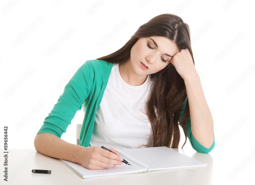 Young casual woman writing in workbook. Young casual woman writing in workbook.