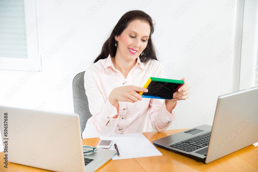 Beautiful business woman looking at the photo frame Beautiful business woman looking at the photo frame