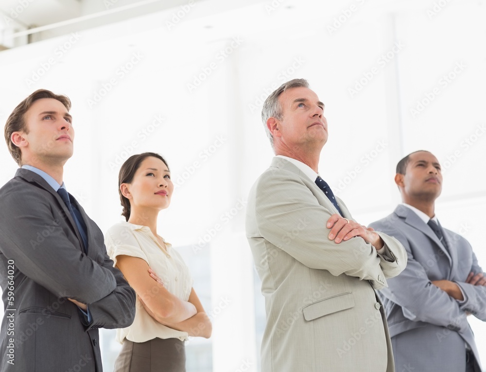 Serious business team with arms crossed looking up Serious business team with arms crossed looking up