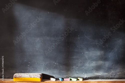 Blank blackboard with colored chalks photo