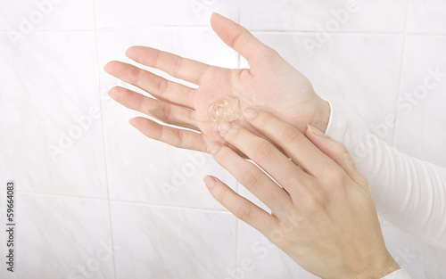 Hands applying sanitizer gel