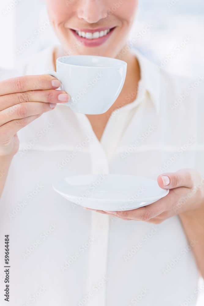 Mid section of a businesswoman with tea cup Mid section of a businesswoman with tea cup