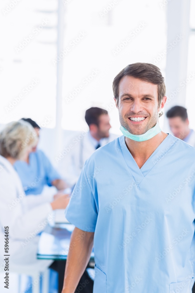 Smiling male surgeon with colleagues in meeting Smiling male surgeon with colleagues in meeting