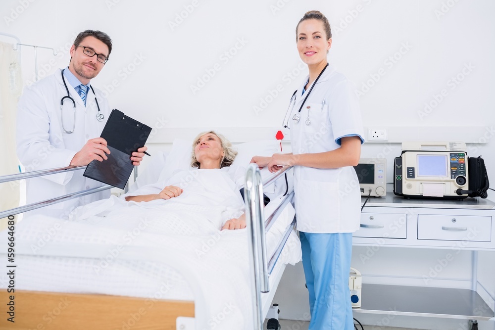 Doctors visiting a female patient in hospital Doctors visiting a female patient in hospital