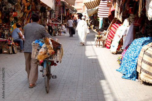 Homme poussant un vélo dans le souk de Marrakech