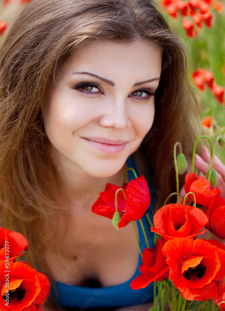 Portrait of a cheerful woman outdoors with red poppy flowers Portrait of a cheerful woman outdoors with red poppy flowers