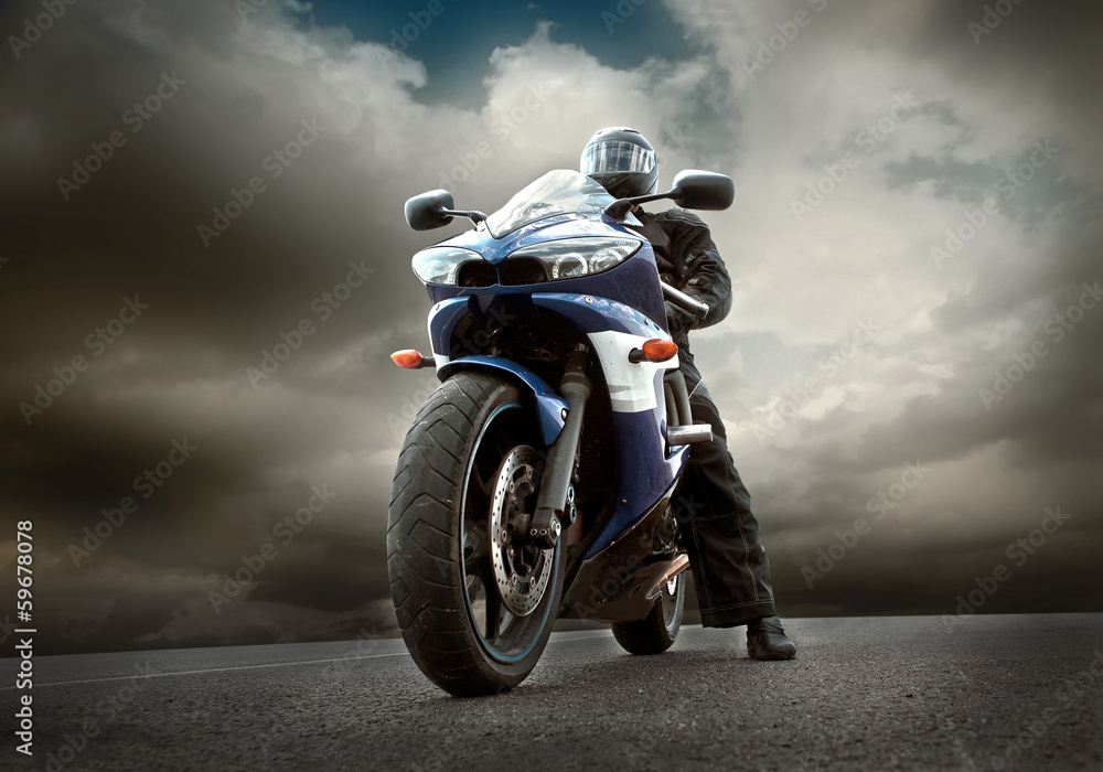 Man seat on the motorcycle under sky with clouds Man seat on the motorcycle under sky with clouds