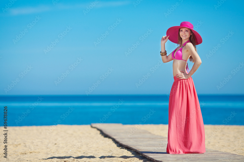 Young beautiful woman on the beach near the sea in summer