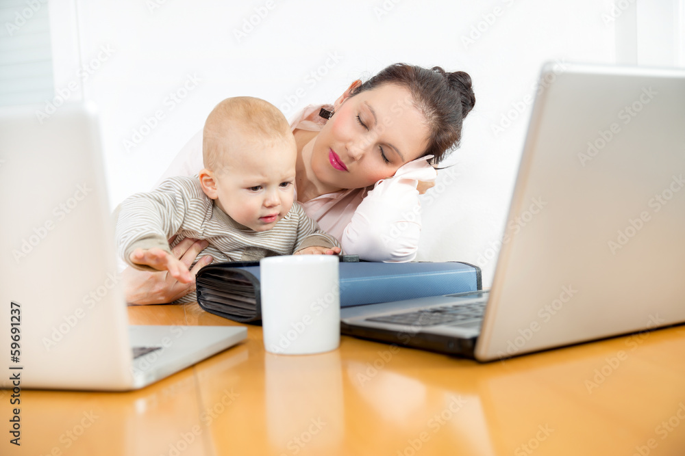 Young businesswoman resting head on laptop keyboard in a office Young businesswoman resting head on laptop keyboard in a office