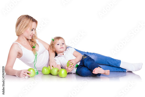 portrait of young mother and little daughter with apples