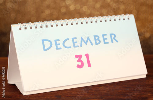 New Year calendar on wooden table, on shiny golden background