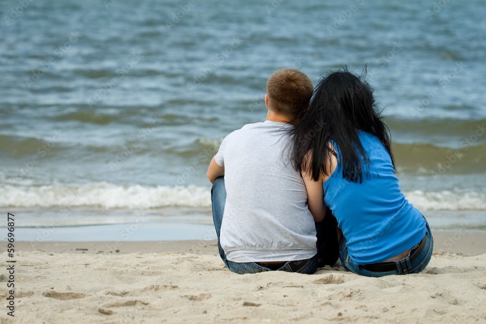 loving young couple is sitting near the sea loving young couple is sitting near the sea