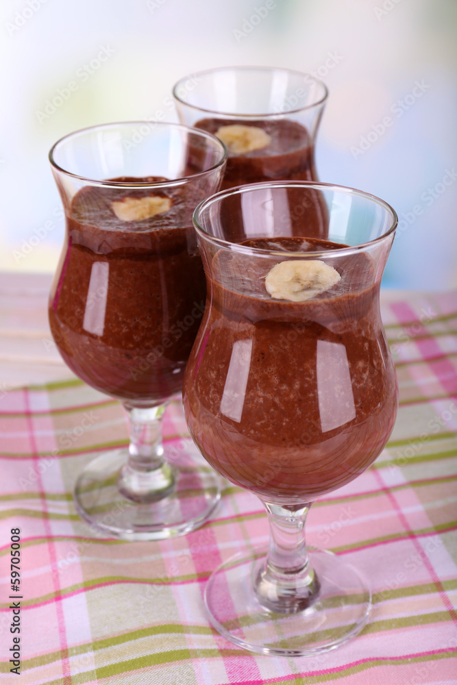 Cocktails with banana and chocolate on table on light Cocktails with banana and chocolate on table on light